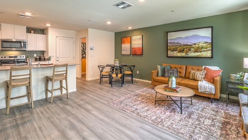 The Canyon Trails 1309 Plan open concept Great Room with LVP panel flooring and two windows.