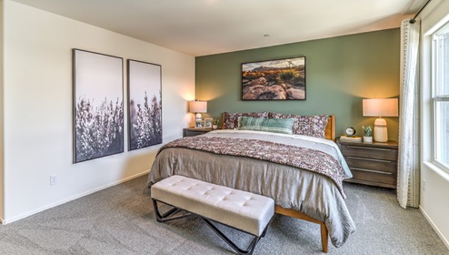 The Bedroom One Suite in our Canyon Trails 1309 model with carpet flooring, an accent wall, walk-in closet, recessed ceiling lights and two windows.