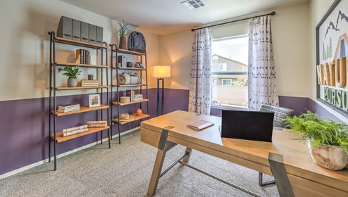 The Office/Bedroom Three option in our Canyon Trails 1309 model with carpet flooring and a sliding closet, furnished with a desk and chair.