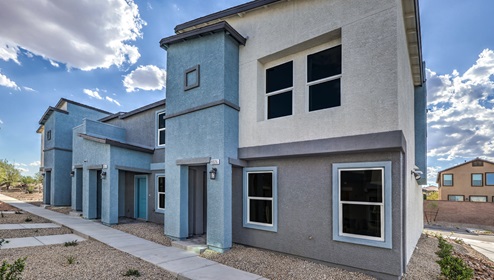 Canyon Trails community with a paver driveway and walkway, a 2-car garage, and lighted address numbers.
