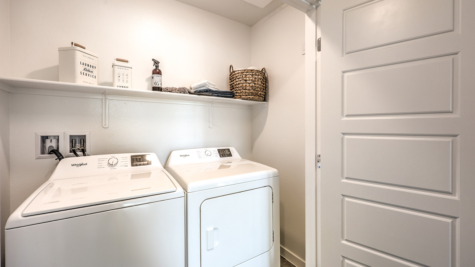 Our Canyon Trails  1309 model laundry room with a shelf and washer and dryer.
