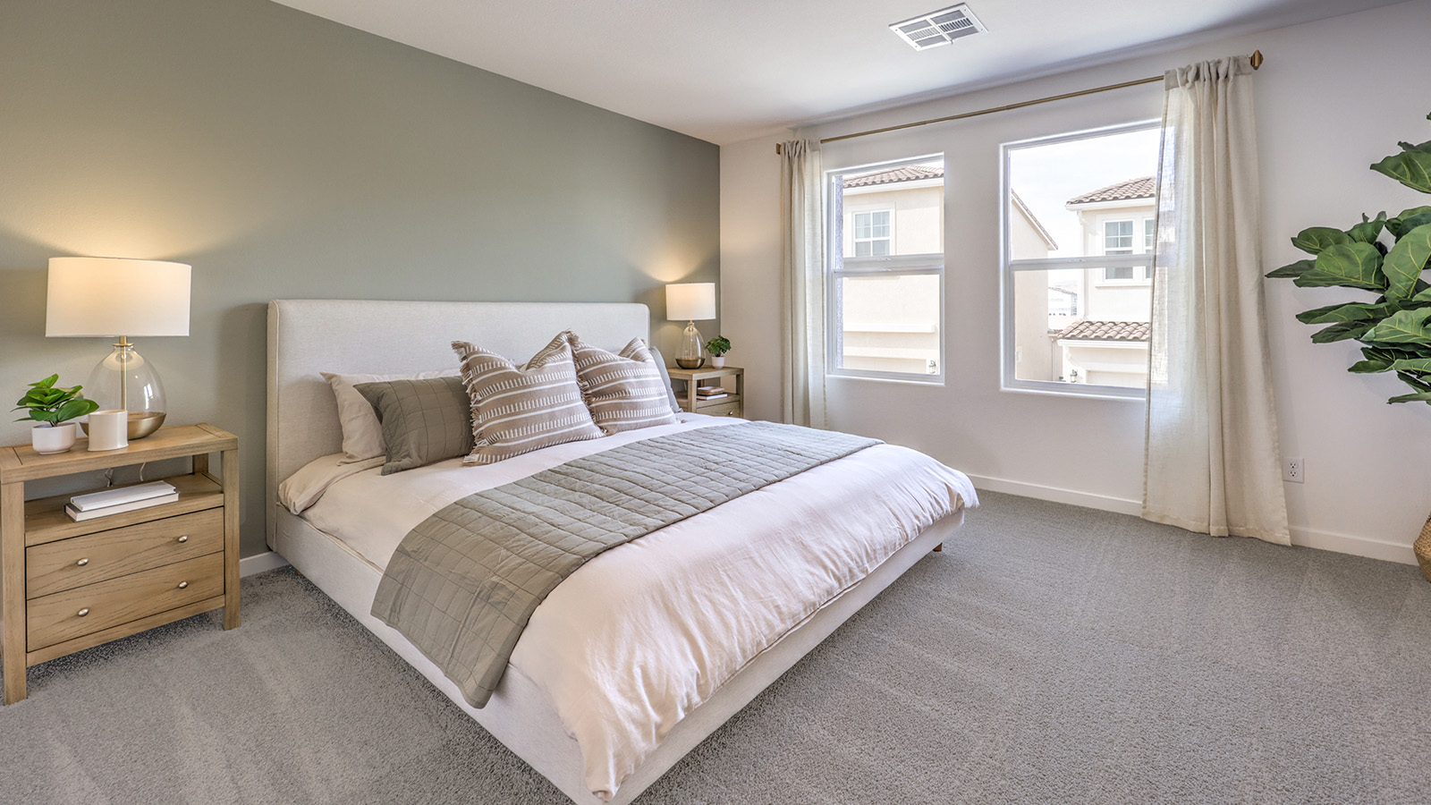 The Bedroom One Suite in our Canyon Trails 1410 model with carpet flooring, an accent wall, two windows.