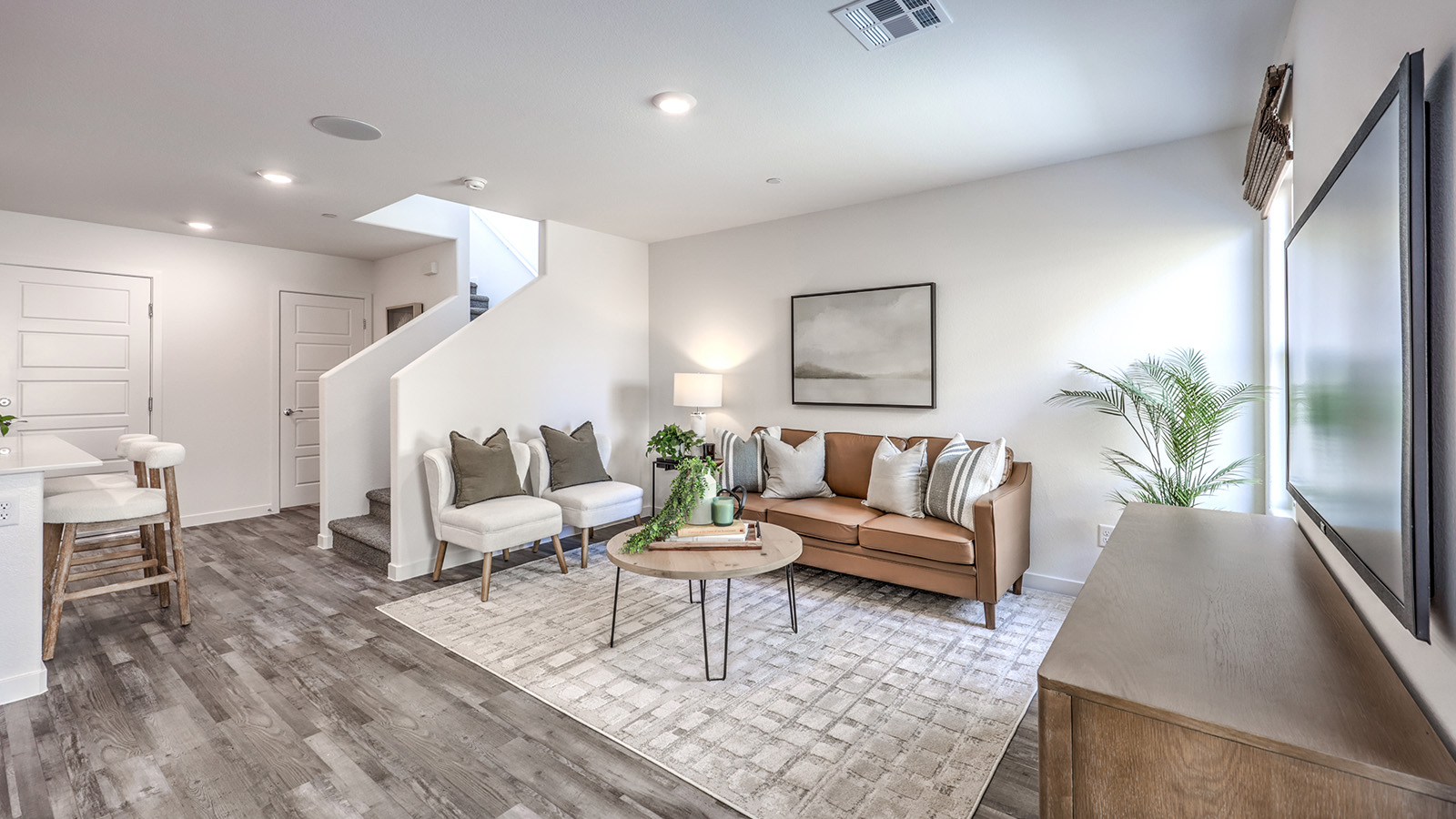 The Canyon Trails 1410 Plan open concept Great Room with LVP panel flooring and two windows.