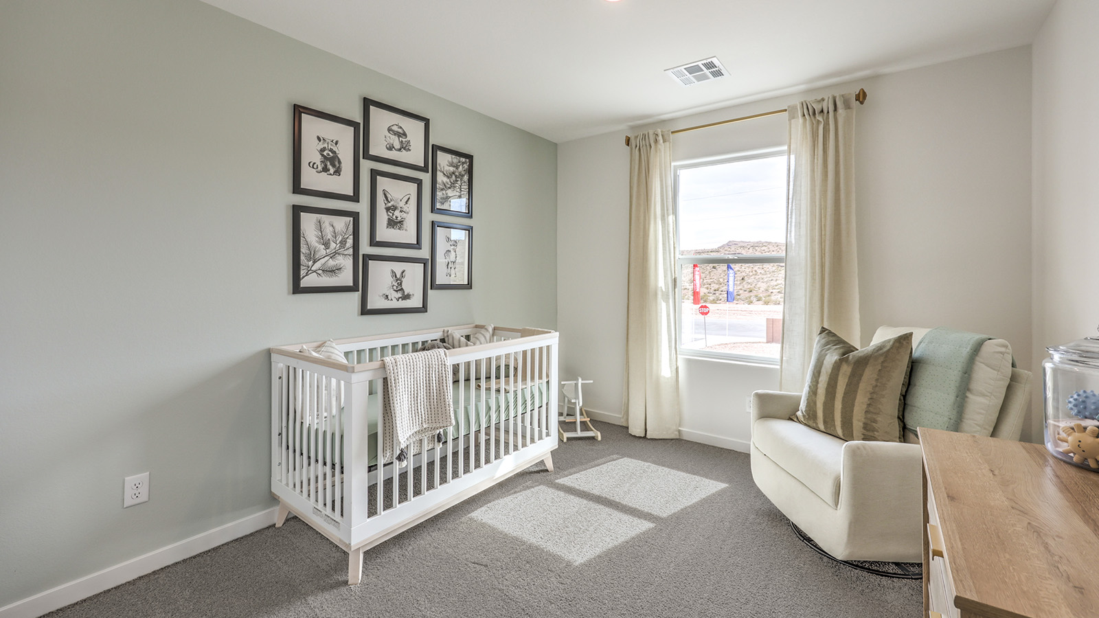 The Office/Bedroom Two option in our Canyon Trails 1410 model with carpet flooring and a window, furnished a crib.