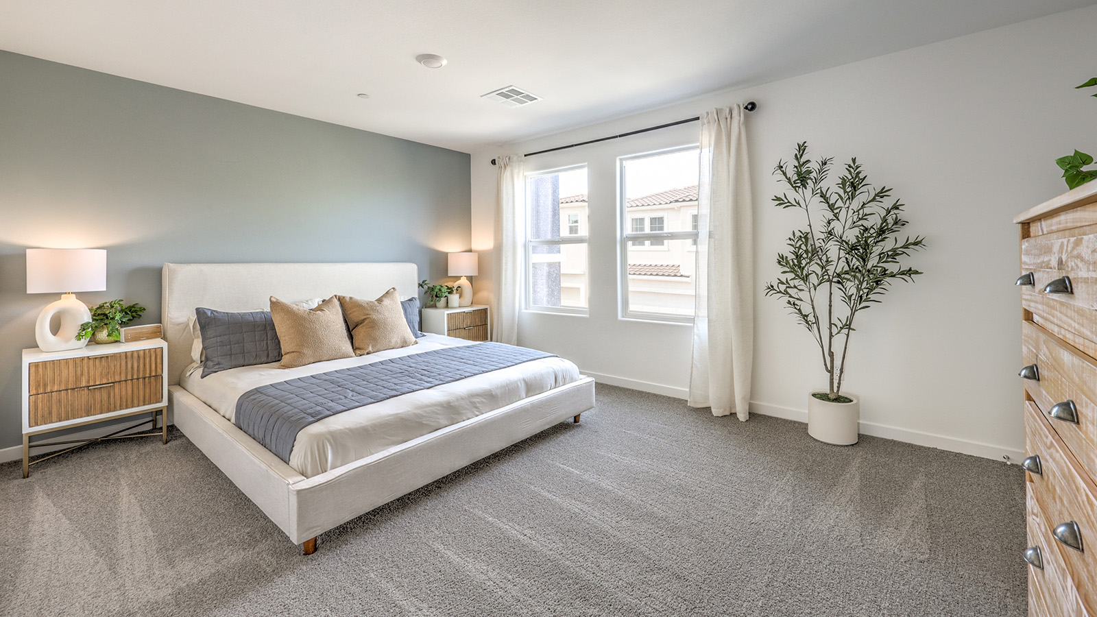 The Bedroom One Suite in our Canyon Trails  1309 model with carpet flooring, a walk-in closet, windows, and recessed ceiling lights.