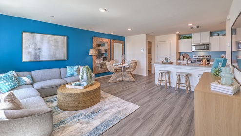 Kalea Trails townhomes have an open floor concept. You will enter to a spacious great room. This specific floor plan is modeled with a large couch, coffee table, and entertainment center. From the great room you can view the dining room ad open kitchen