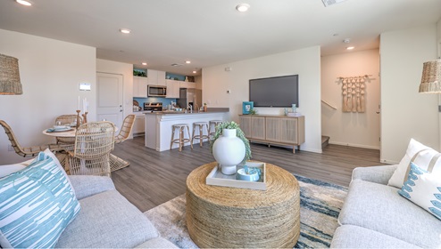 Kalea Trails townhomes have an open floor concept. You will enter to a spacious great room. This specific floor plan is modeled with a large couch, coffee table, and entertainment center. From the great room you can view the dining room ad open kitchen