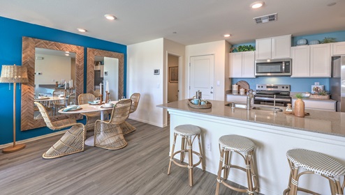 Kalea Trails townhomes have an open floor concept. You will enter to a spacious great room. This specific floor plan is modeled with a large couch, coffee table, and entertainment center. From the great room you can view the dining room ad open kitchen