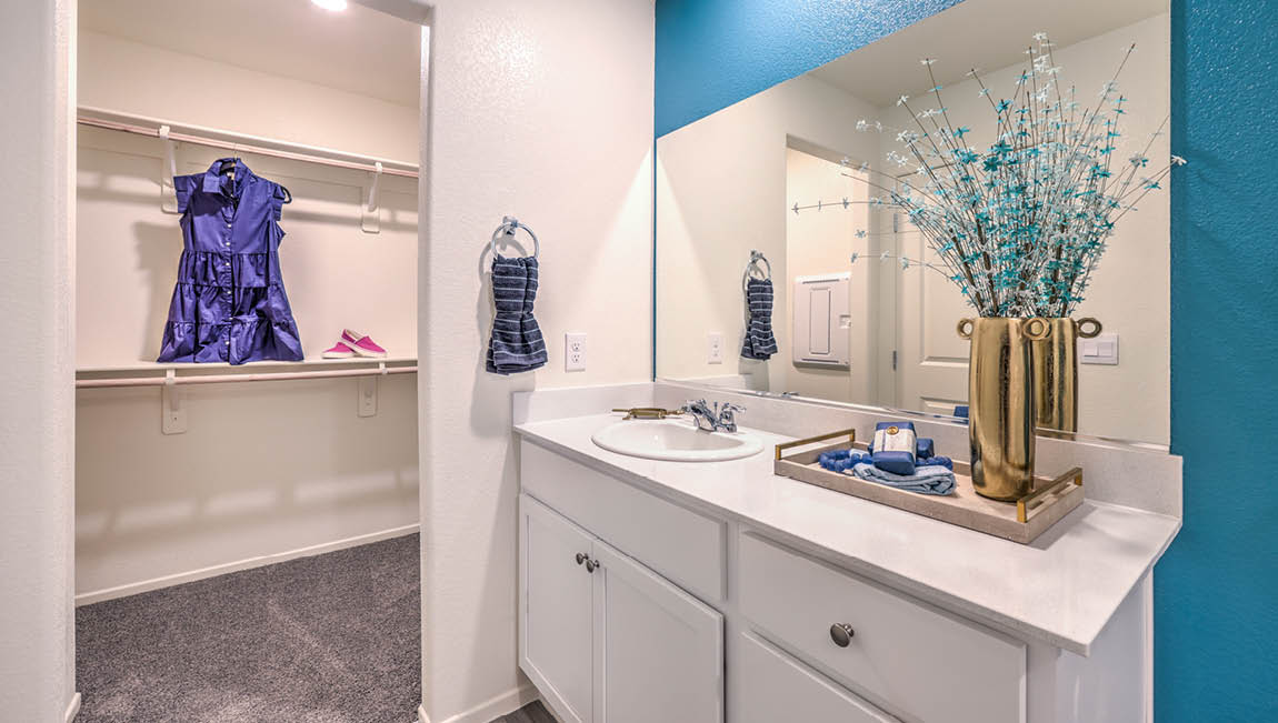 Attached to the Bedroom One Suite, our 1430 model bathroom with granite countertops at the Bath Vanity, a walk-in closet, mirror, and white cabinets.