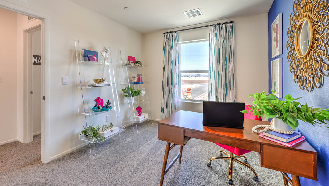 The Office/Bedroom Two option in our Kalea Trails 1430 model with carpet flooring, a sliding closet, and a window, furnished with a desk and chair.