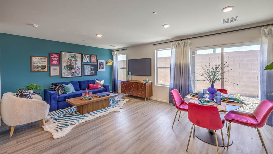 The Kalea Trails 1430 Plan open concept Great Room with LVP panel flooring, two windows, and a sliding door to the backyard.