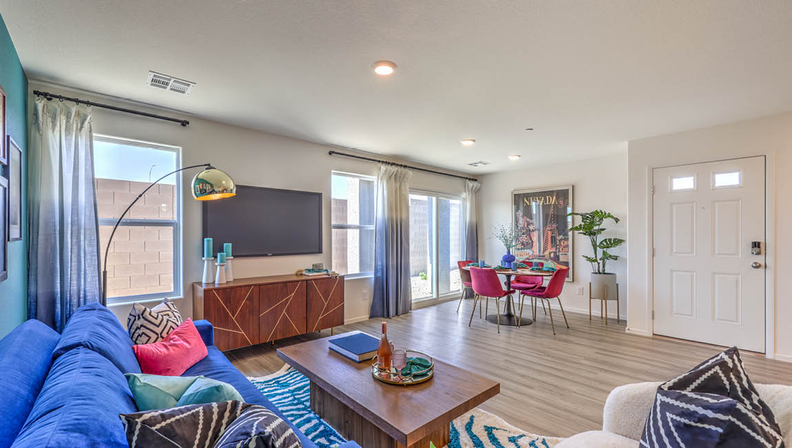 The Kalea Trails 1430 Plan open concept Great Room with LVP panel flooring, two windows, and a sliding door to the backyard.