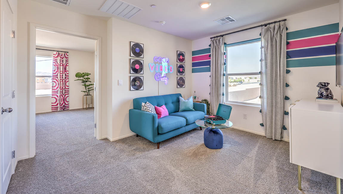 The upstairs loft in our Kalea Trails 1430 model with a window and carpet flooring.