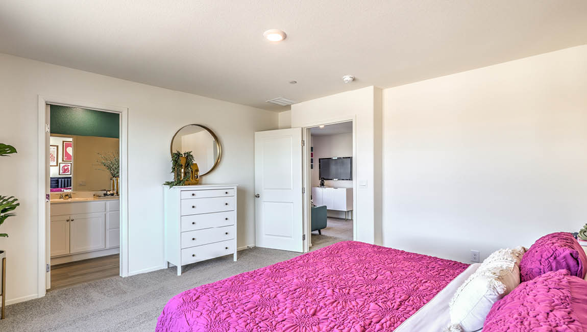 The Bedroom One Suite in our Kalea Trails 1430 model with carpet flooring, recessed ceiling lights, and a walk-in closet.
