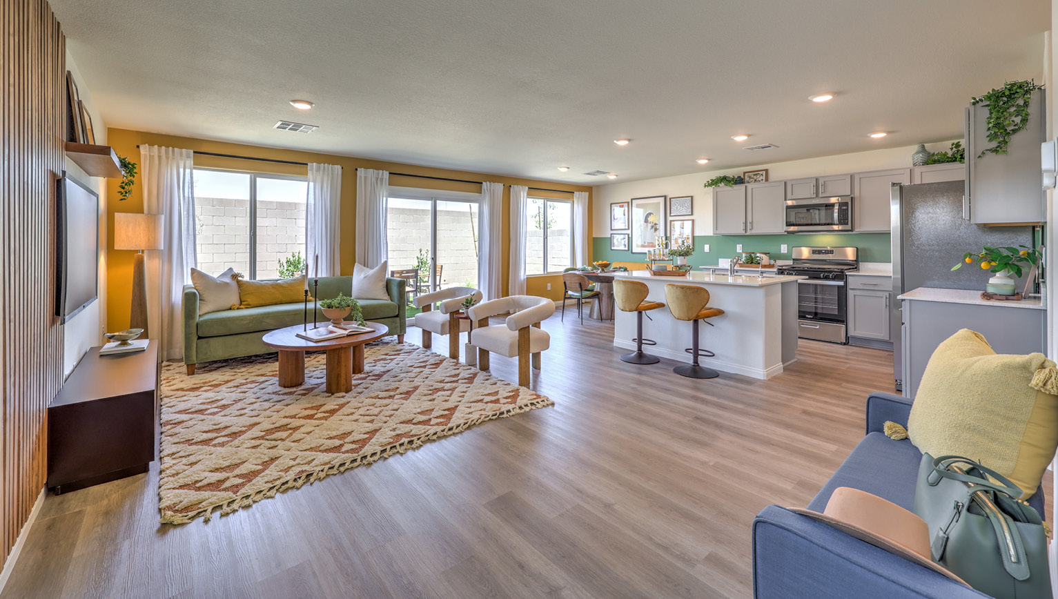 The Kalea Bay 1865 Plan open concept Great Room with LVP panel flooring, large windows, and a sliding door to the backyard.