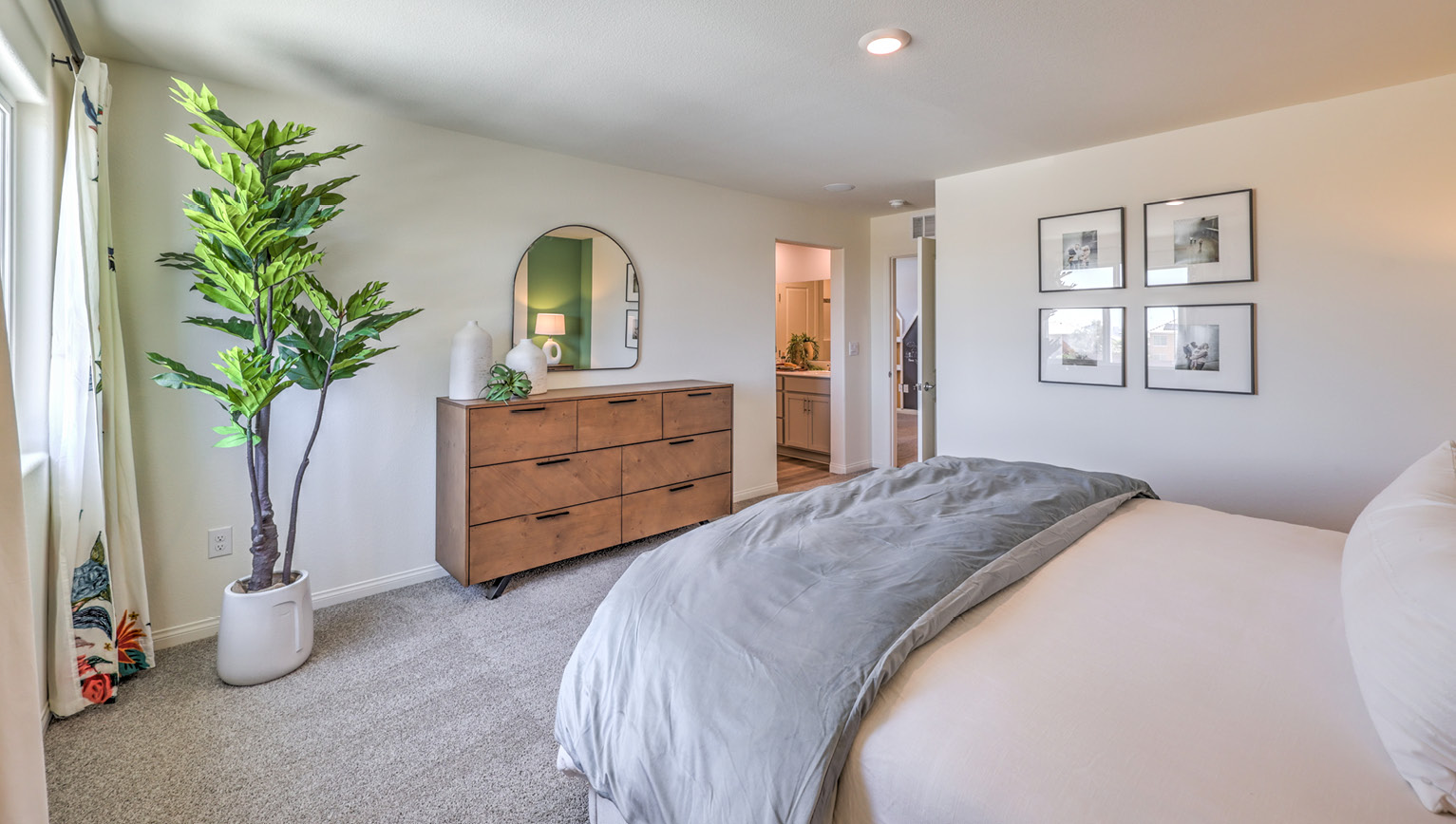 The Bedroom One Suite in our Kalea Bay 1865 model with carpet flooring, recessed ceiling lights, walk-in closet, and a large window.