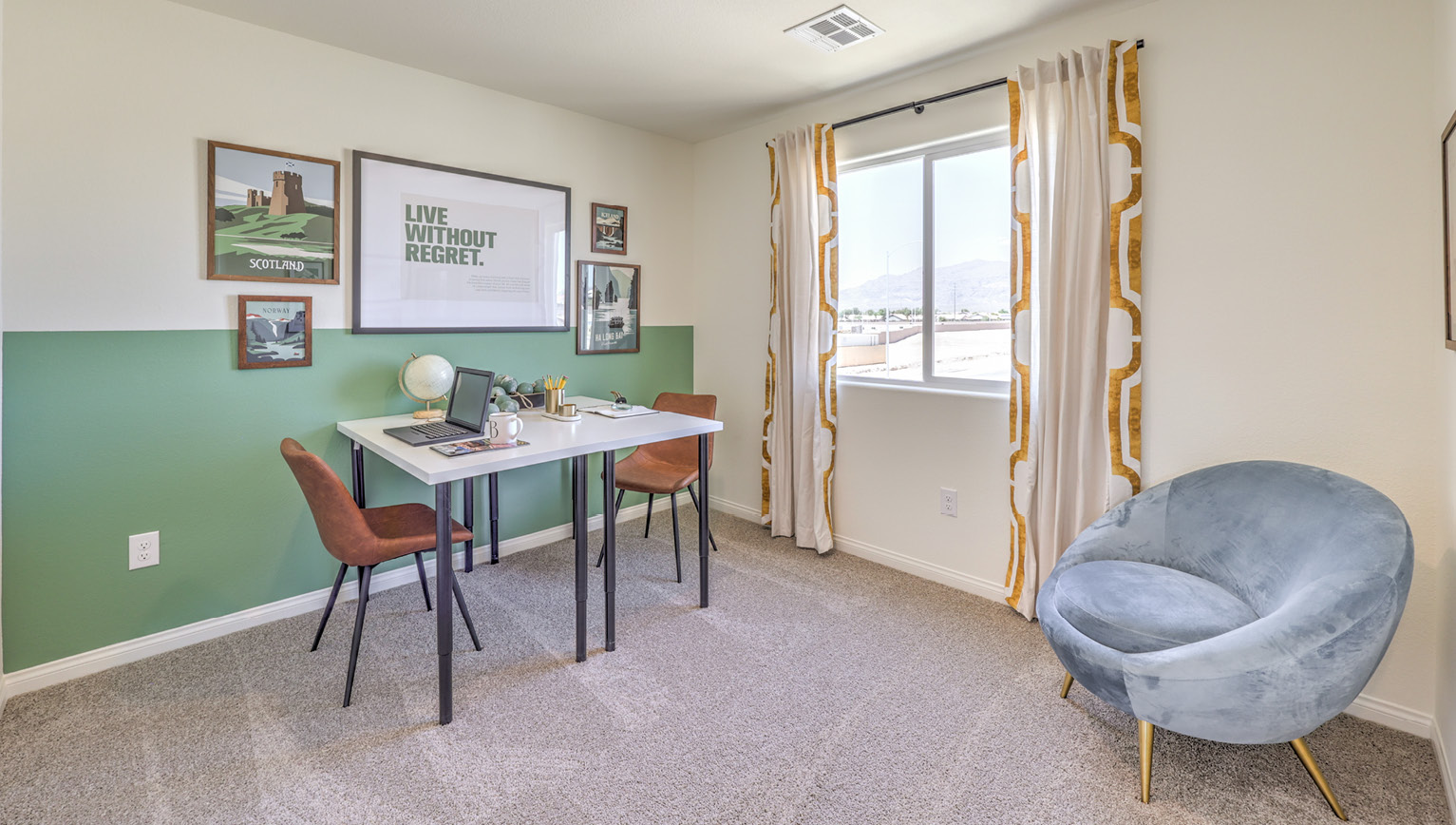 The Office/Bedroom Two option in our Kalea Bay 1865 model with carpet flooring and a window, furnished with a desk and two chairs.