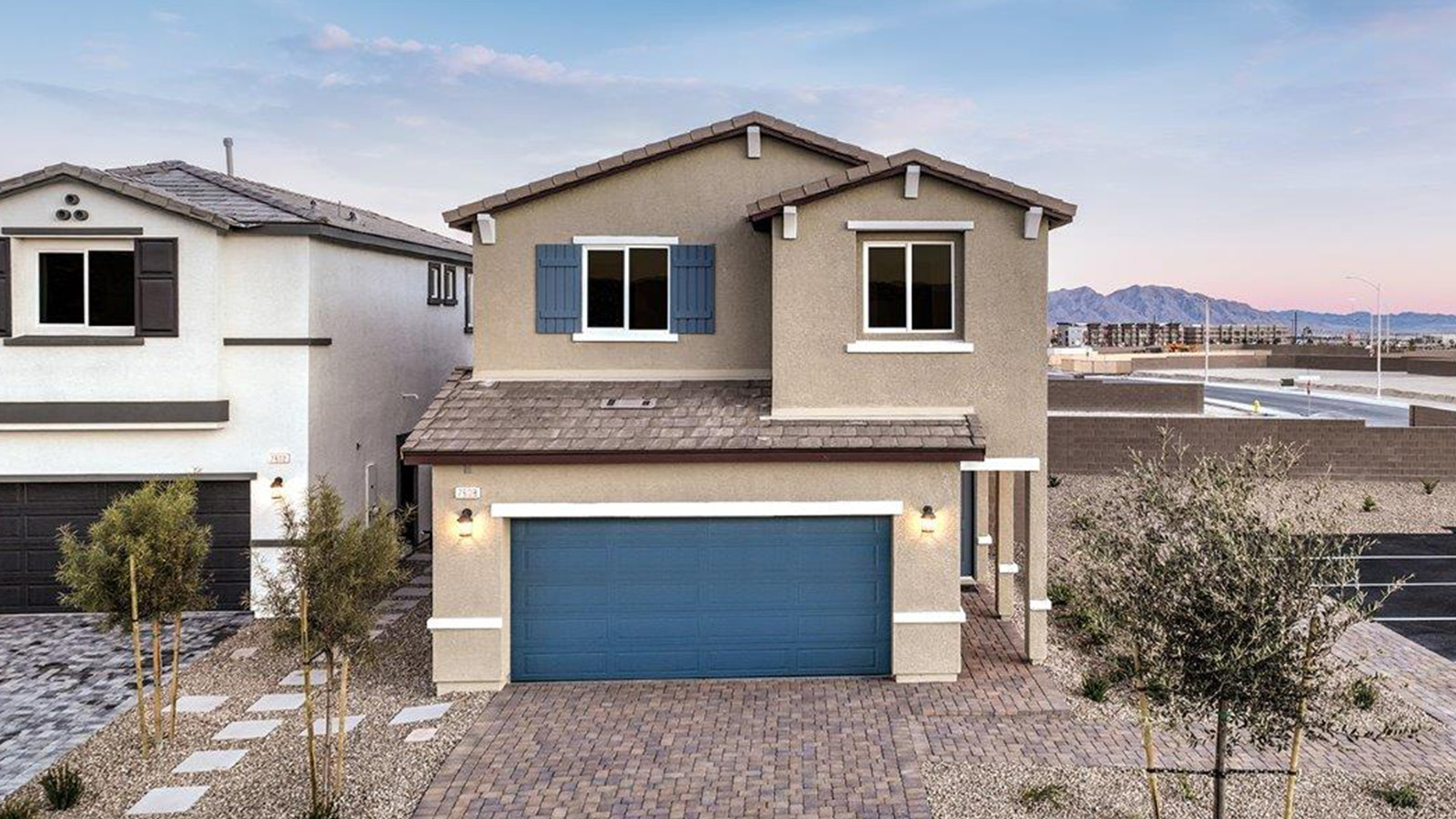 Exteriors in our Heartland Bay Community featuring front yard landscaping, paver driveways, and two-car garages.