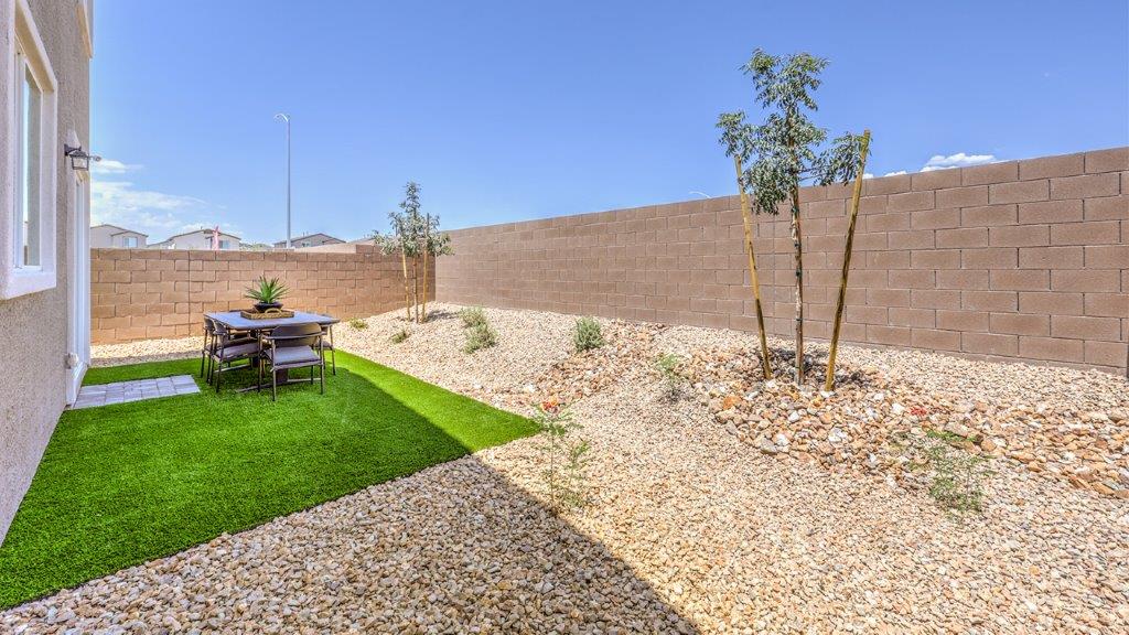 The backyard in our Heartland Falls 3000 plan with landscaping and artificial turf.