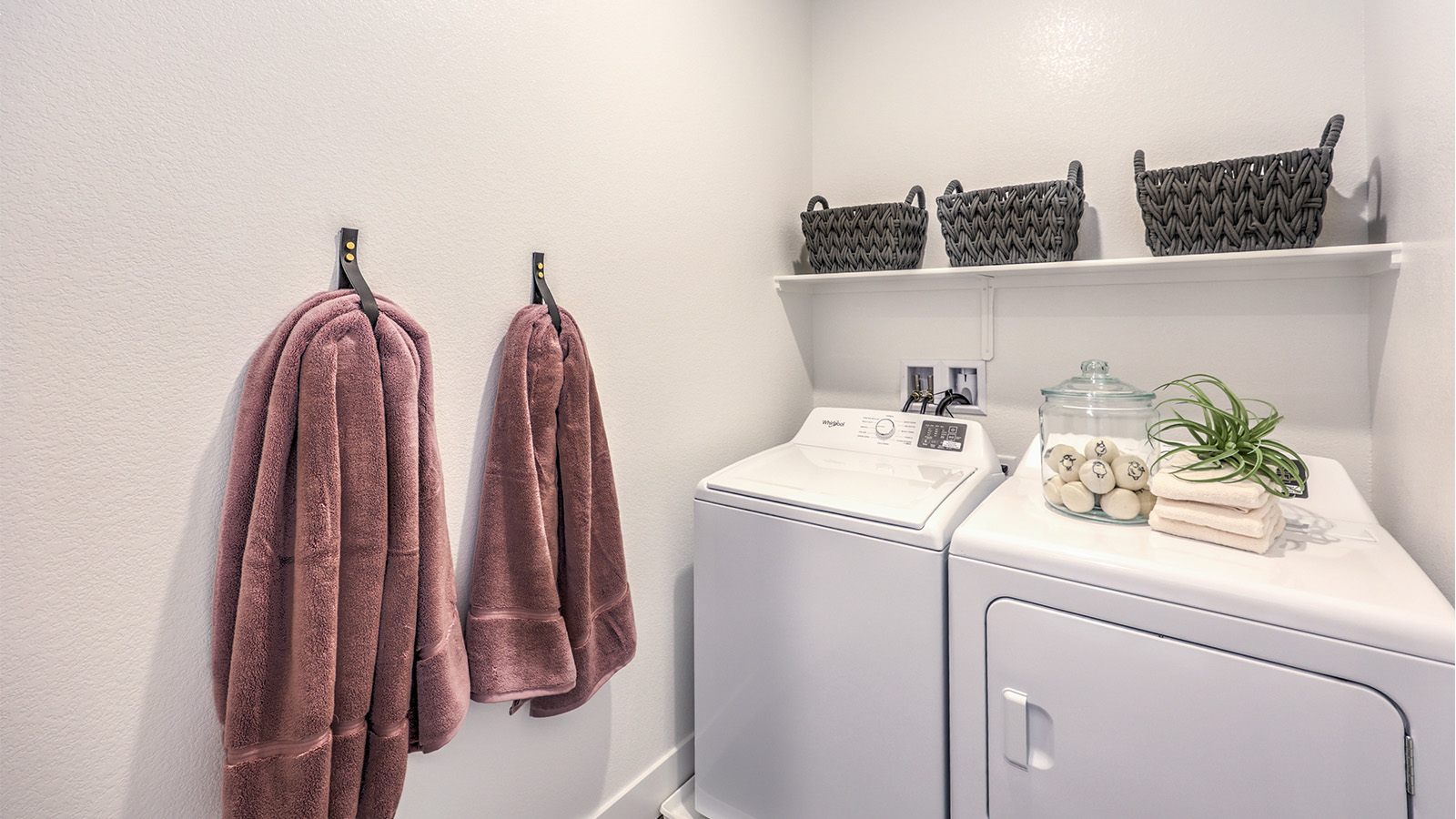 Our Heartland Falls 2660 model laundry room with shelves and a washer and dryer.