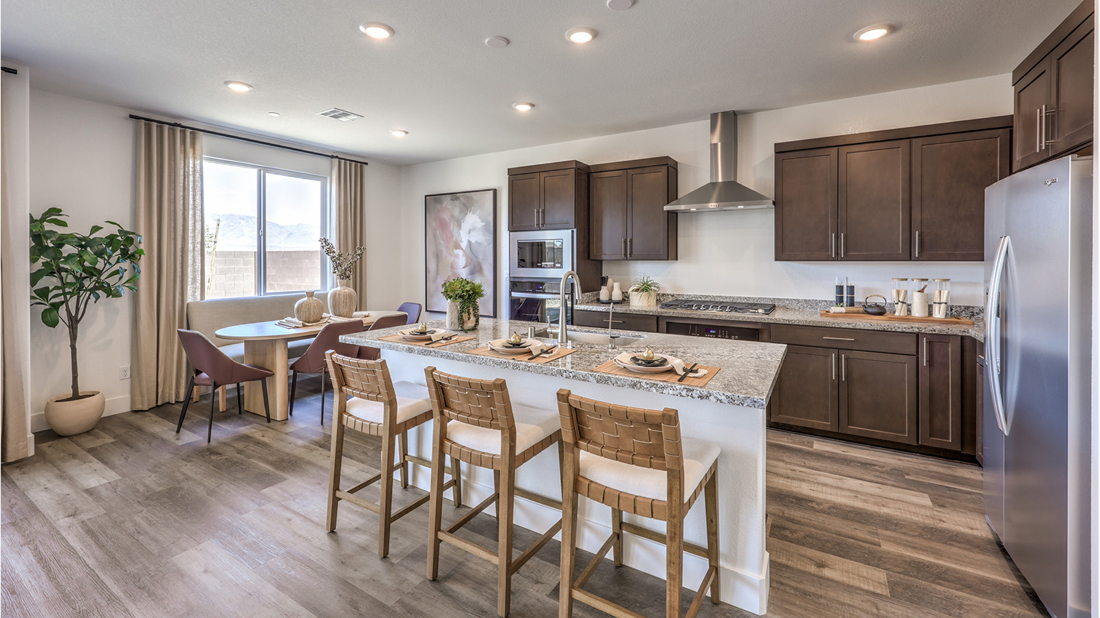 Our 2660 model kitchen in the Heartland Falls Community with grey shaker style cabinets, Granite Slab countertops, a kitchen island, and Whirlpool Stainless Steel appliances.