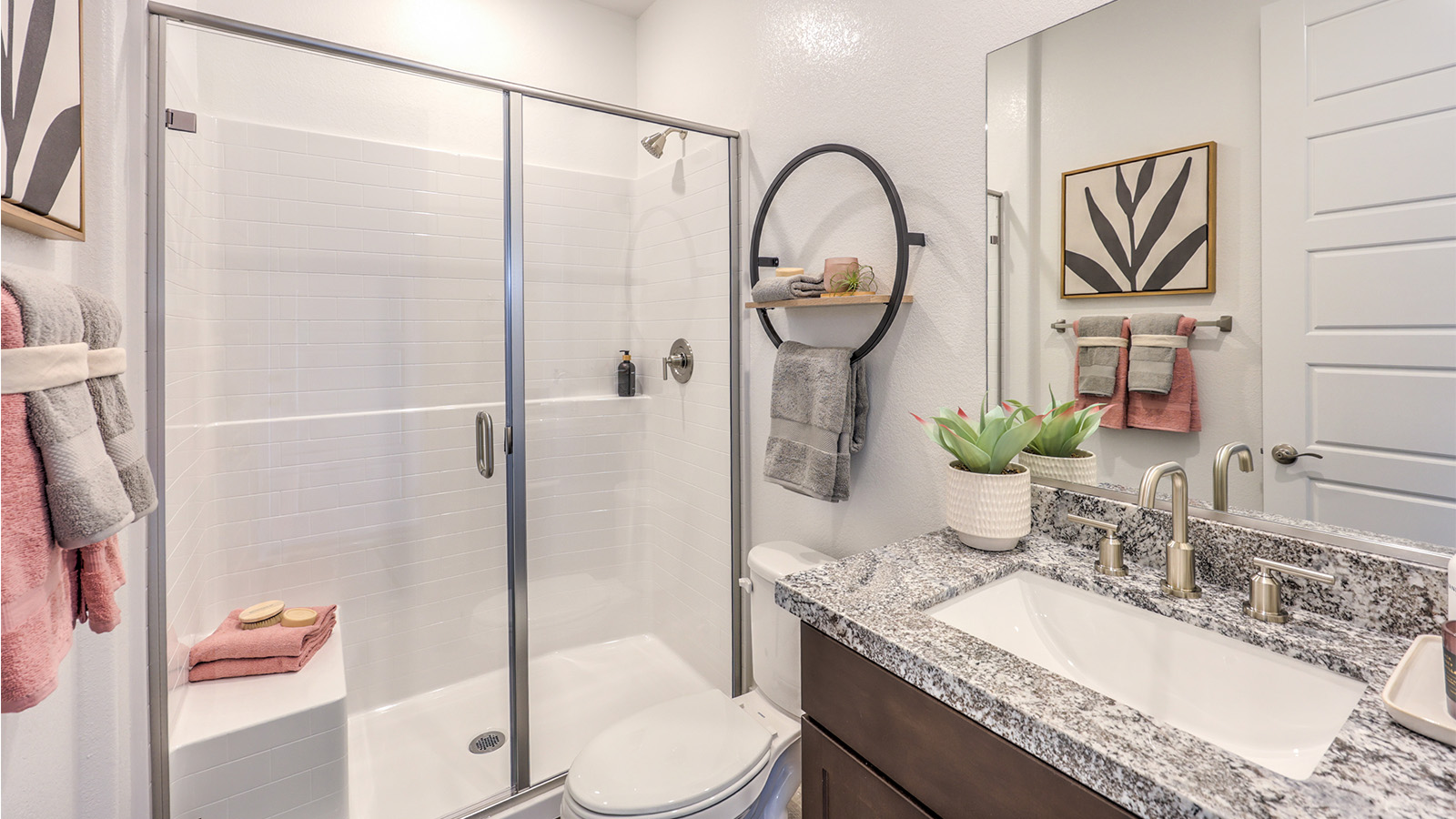Bathroom Two in our Heartland Falls 2660 model with Granite countertops at the double Bath Vanity, a walk-in shower, mirror, and grey cabinets.