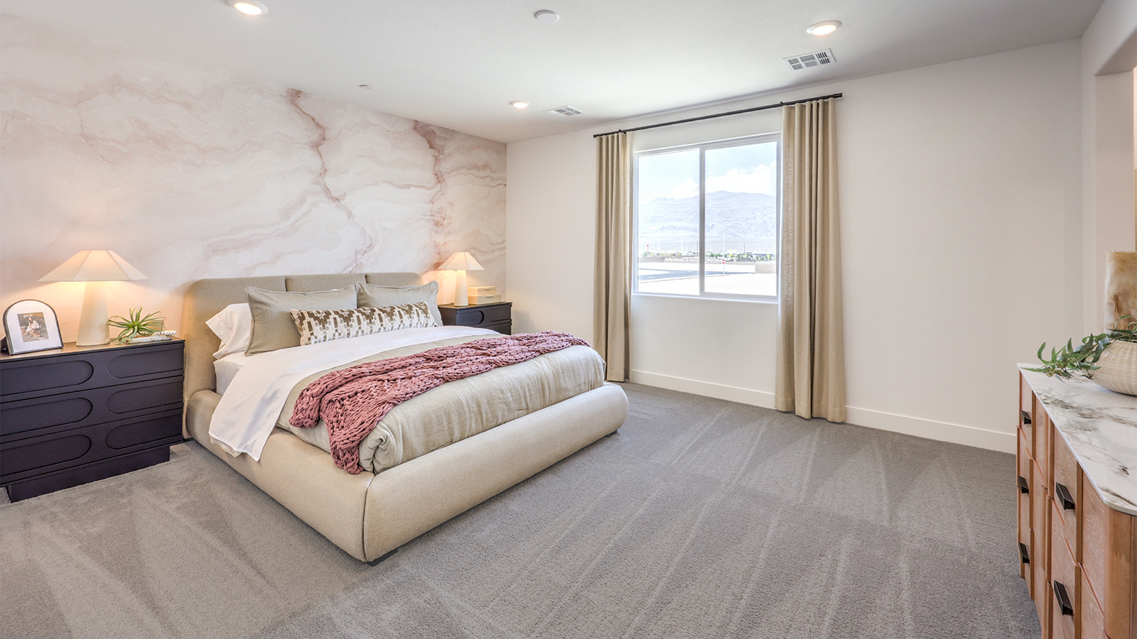 The Bedroom One Suite in our Heartland Falls 2660 model with carpet flooring, ceiling fan with a light kit, and large windows.