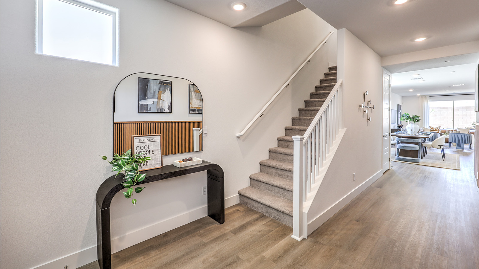 The front door entrance to our Heartland Falls 3000 model with a table and mirror, adjacent to the stairs.