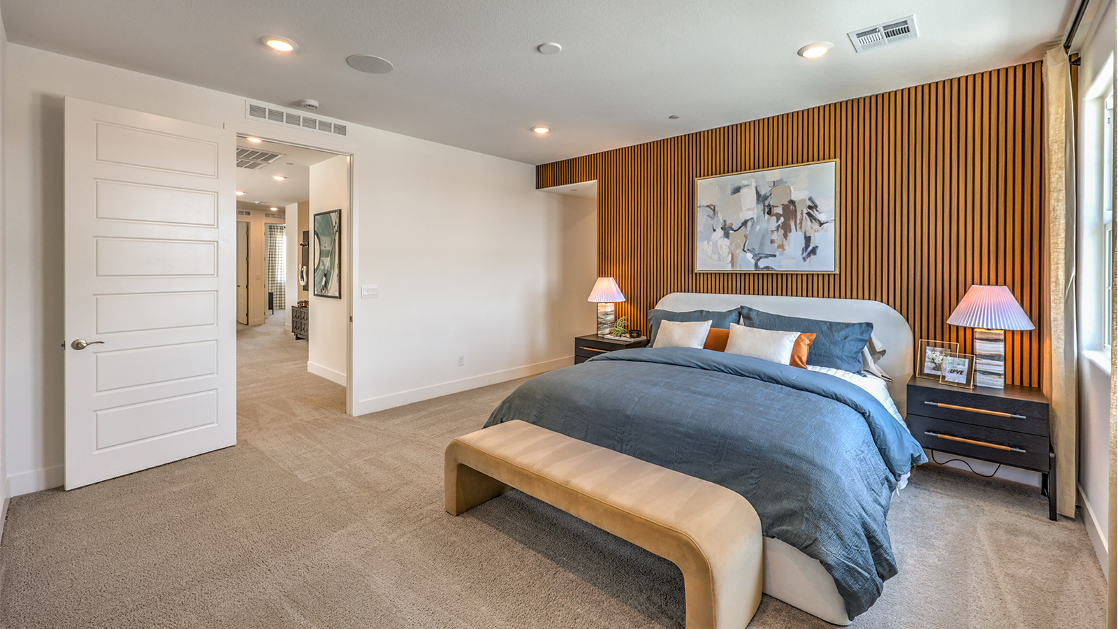 The Bedroom One Suite in our Heartland Falls 3000 model with carpet flooring, ceiling fan with a light kit, and large windows.