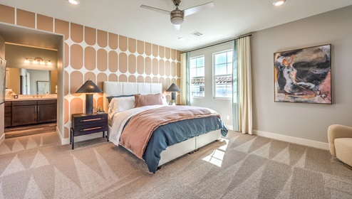 The Bedroom One Suite in our Heartland Falls 3001 model with carpet flooring, ceiling fan with a light kit, and large windows.