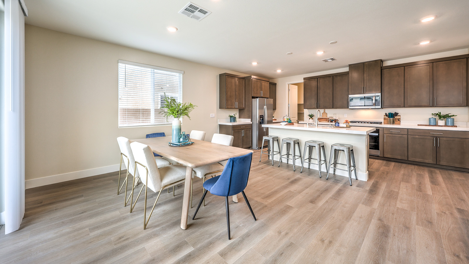 The Heartland Falls 2436 model Dining Room adjacent to the kitchen with a table and window.