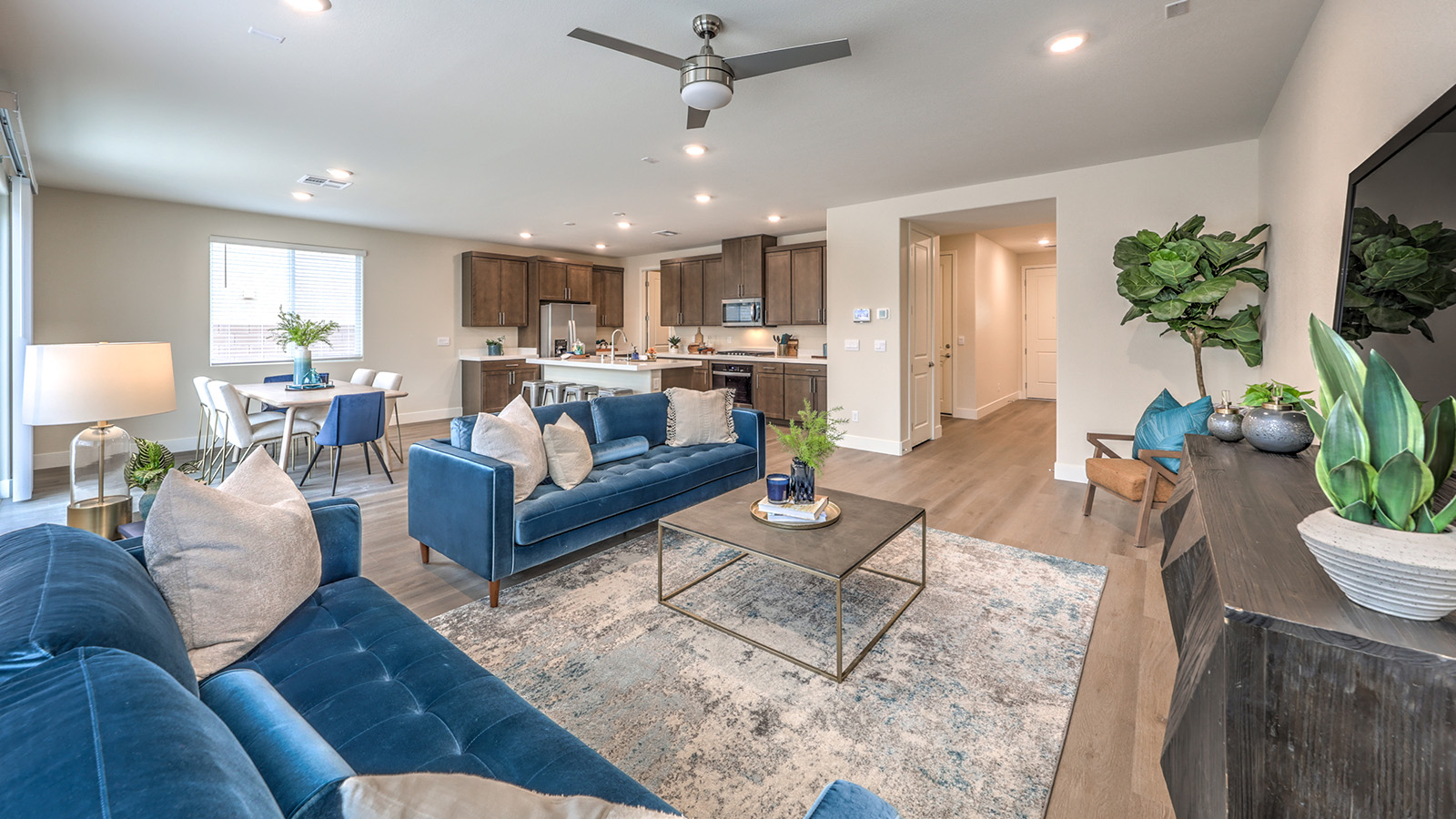 The Heartland Falls 2436 Plan open concept Great Room with ceramic tile flooring, large windows, and a sliding door to the backyard.