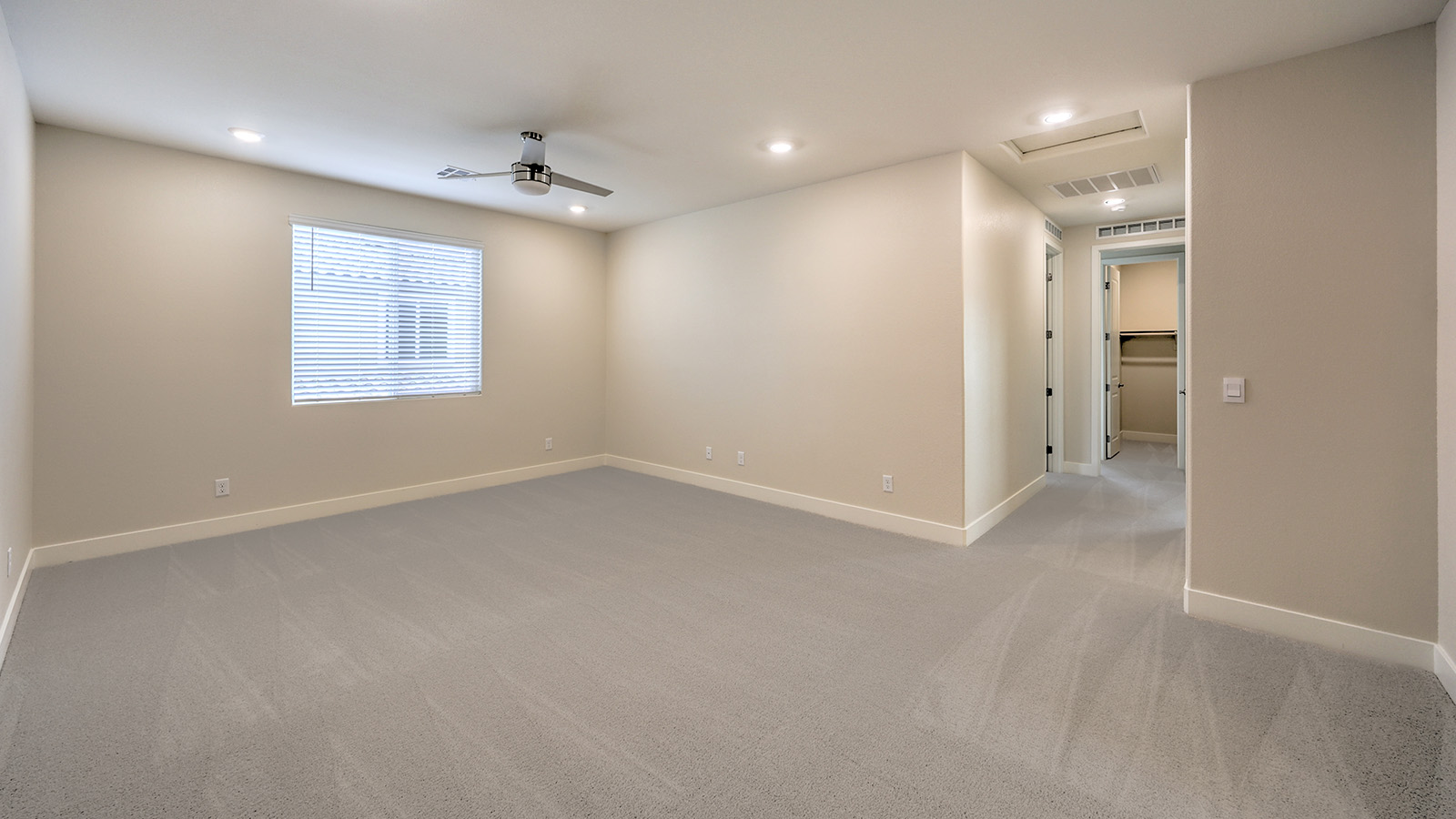 The loft in our Heartland Falls 2436 plan with carpet flooring and a window.