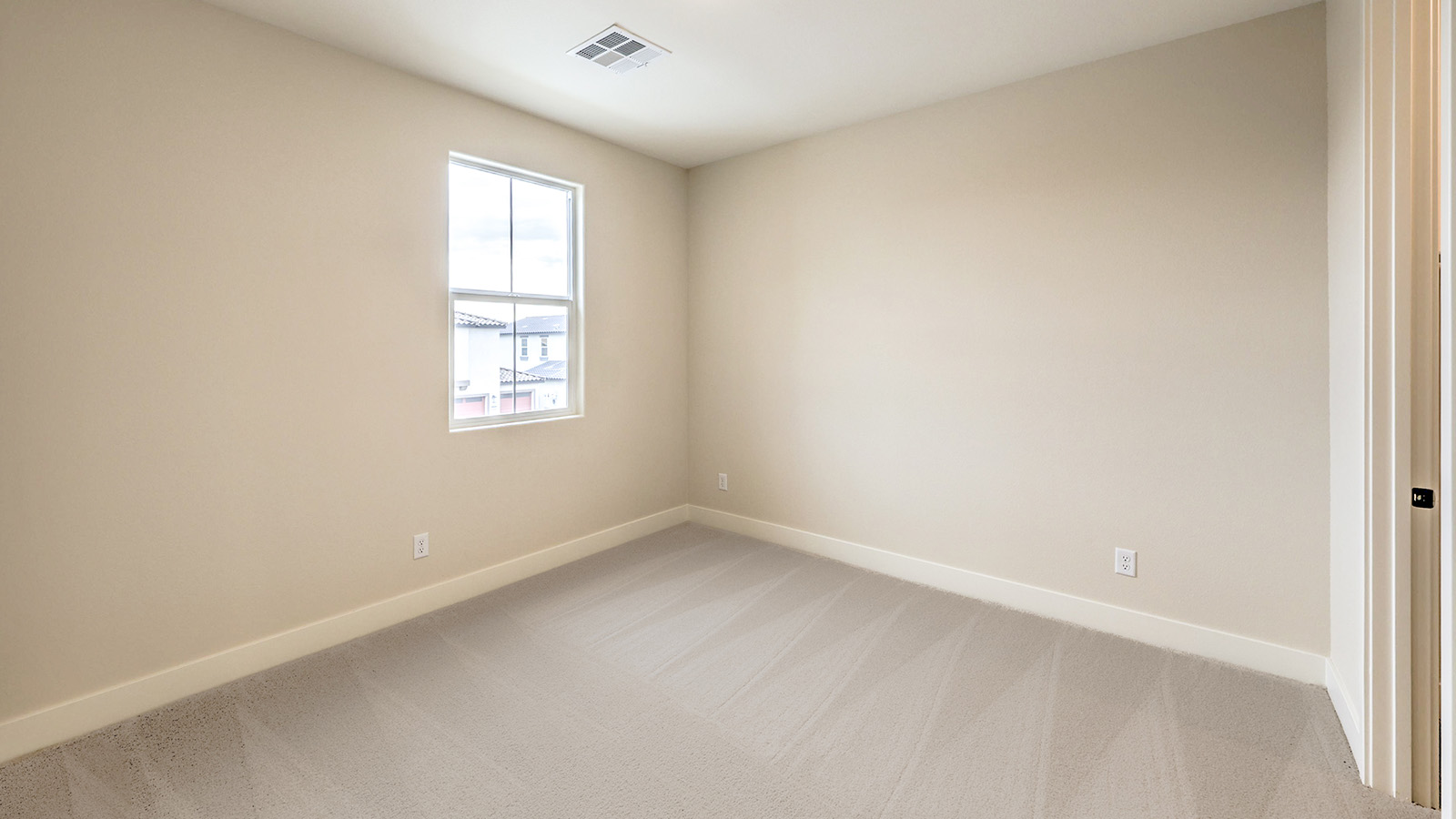 Bedroom Three in our Heartland Falls 2660 model with carpet flooring, a sliding closet, and a window.