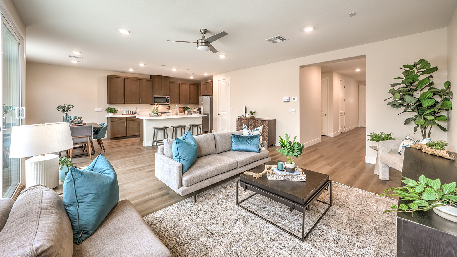 The Heartland Falls 2660 Plan open concept Great Room with ceramic tile flooring, large windows, and a sliding door to the backyard.