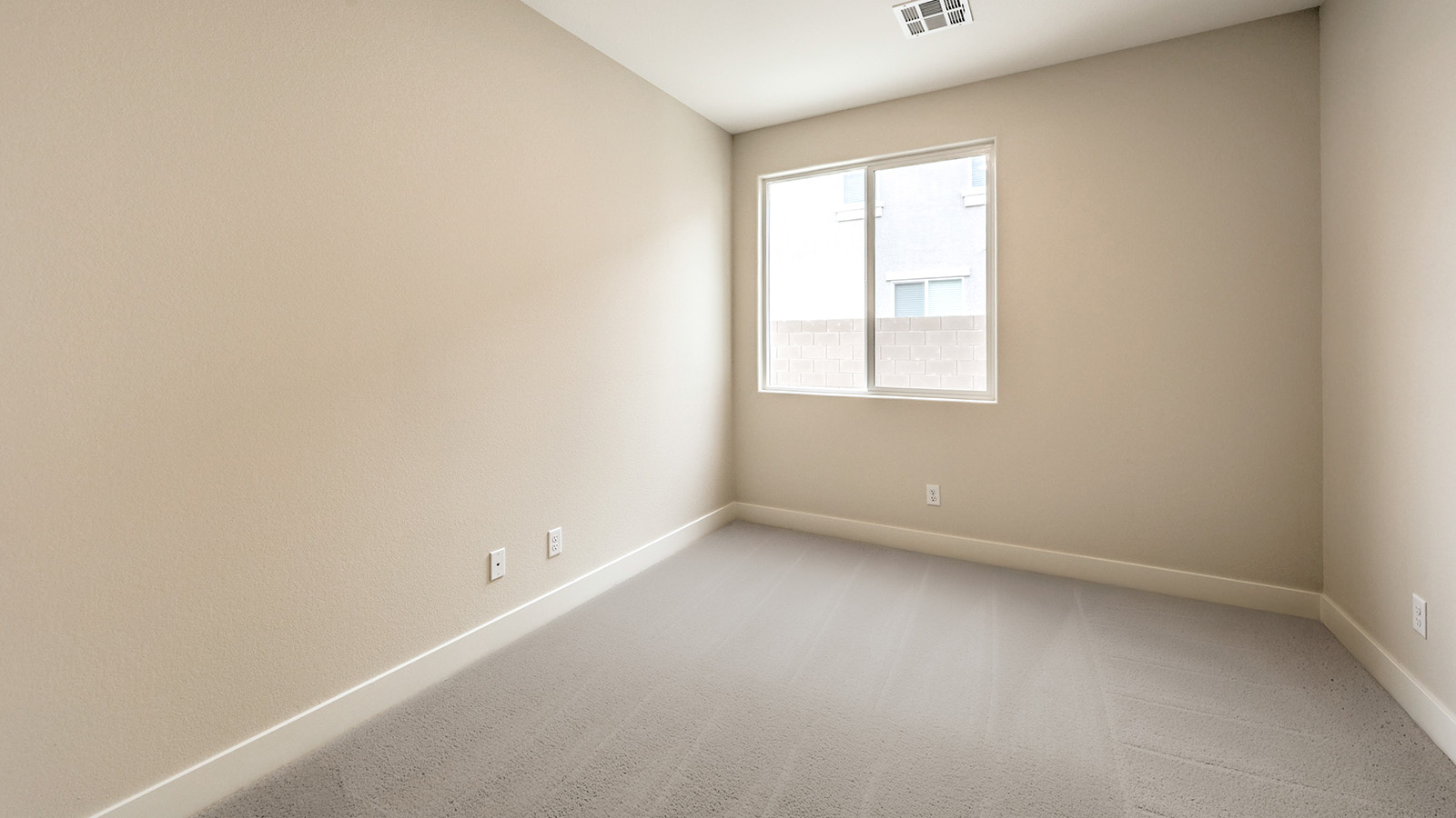 The Bonus Room in our Heartland Falls 2660 plan with carpet flooring and windows.