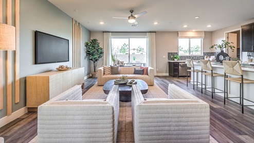 The Heartland Falls 3001 Plan open concept Great Room with Luxury Vinyl Plank Flooring, large windows, and a sliding door to the backyard.