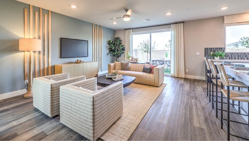 The Heartland Falls 3001 Plan open concept Great Room with Luxury Vinyl Plank Flooring, large windows, and a sliding door to the backyard.