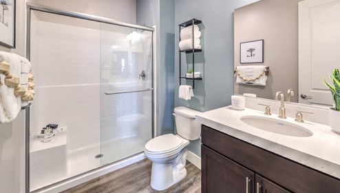 Bathroom Three in our Heartland Falls 3001 model with Granite countertops at the double Bath Vanity, a shower, mirror, and white cabinets.