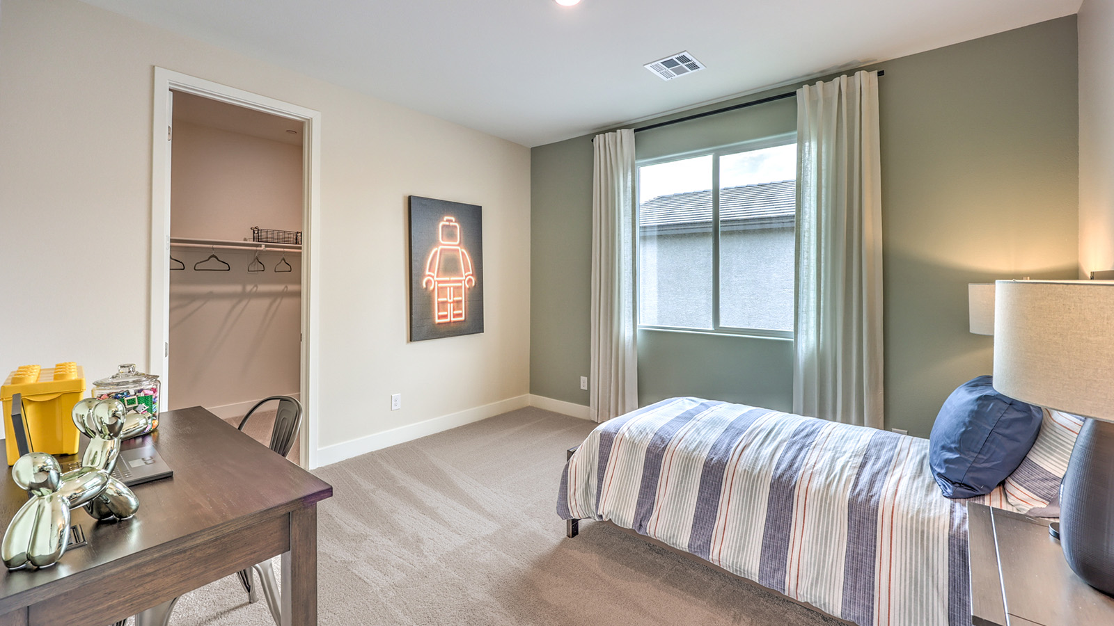 Bedroom Six in our Heartland Summit 4425 Multigen Suite with carpet flooring, a walk-in closet, and a window.
