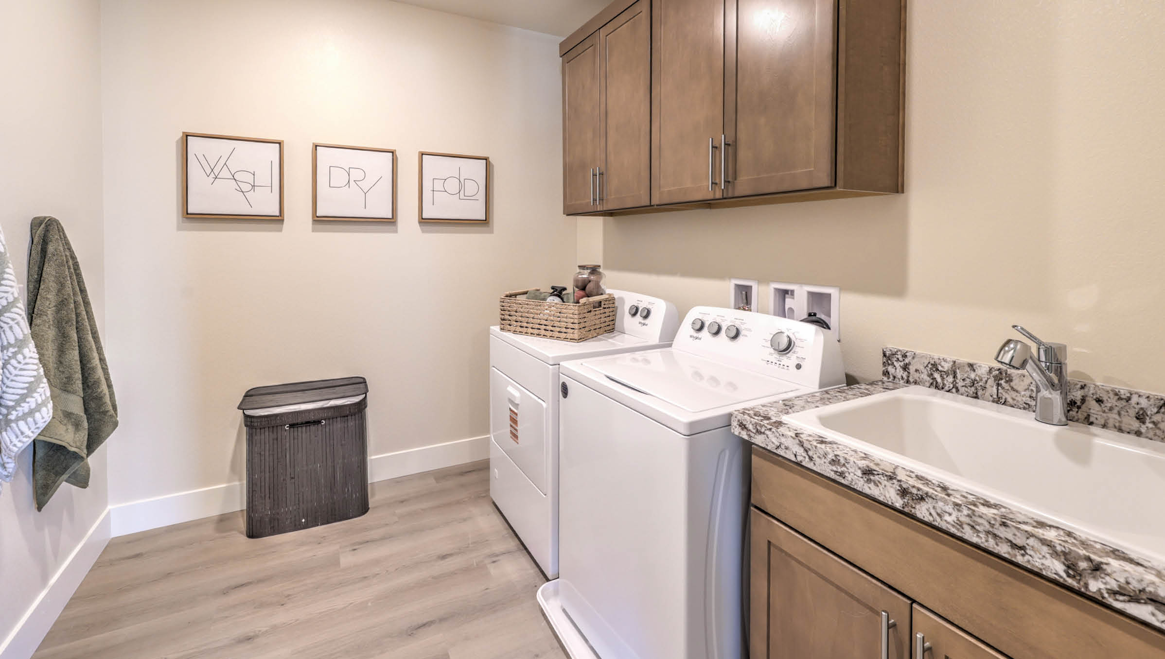 Our Heartland Summit 4425 model laundry room with brown shaker style cabinets and a washer and dryer.
