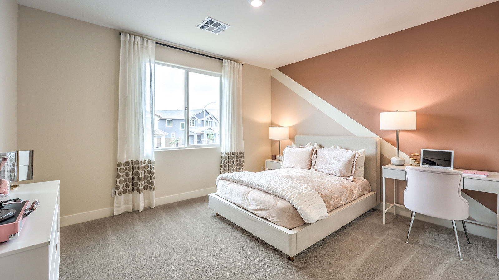 Bedroom Five in our Heartland Summit 4425 model with carpet flooring, a walk-in closet, and a window.