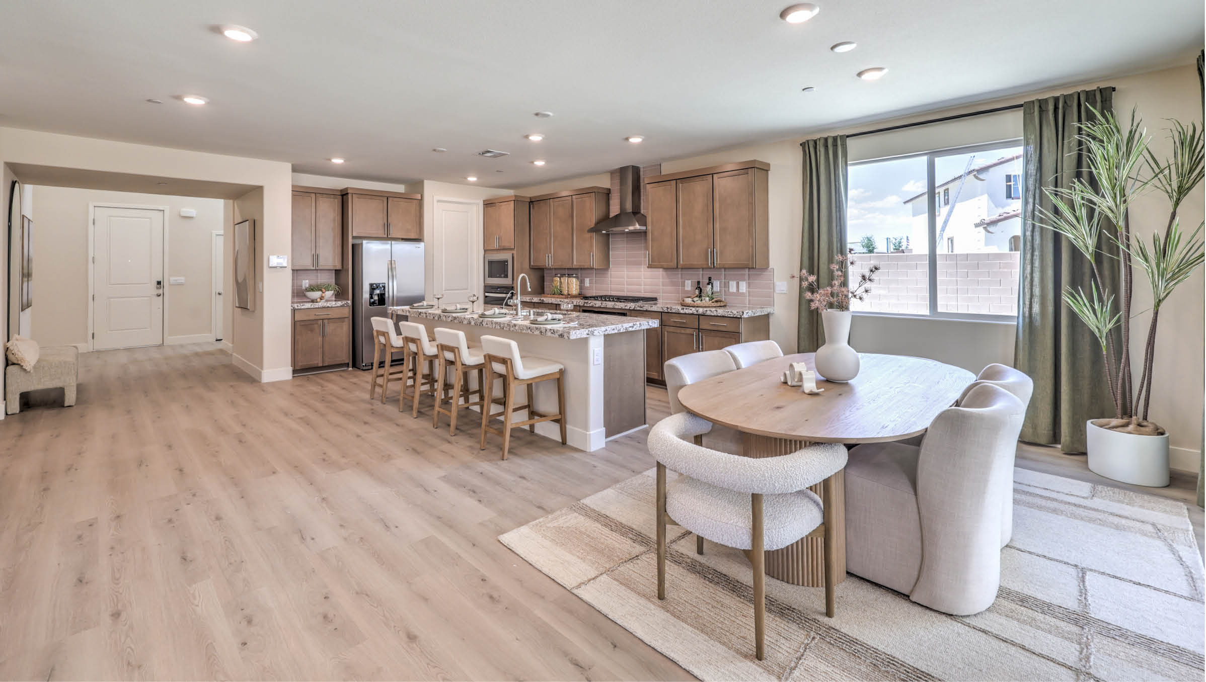 Our 4425 model kitchen in the Heartland Summit Community with brown shaker style cabinets, quartz countertops, a kitchen island, 5-burner cooktop, large pantry, and Whirlpool Stainless Steel appliances.