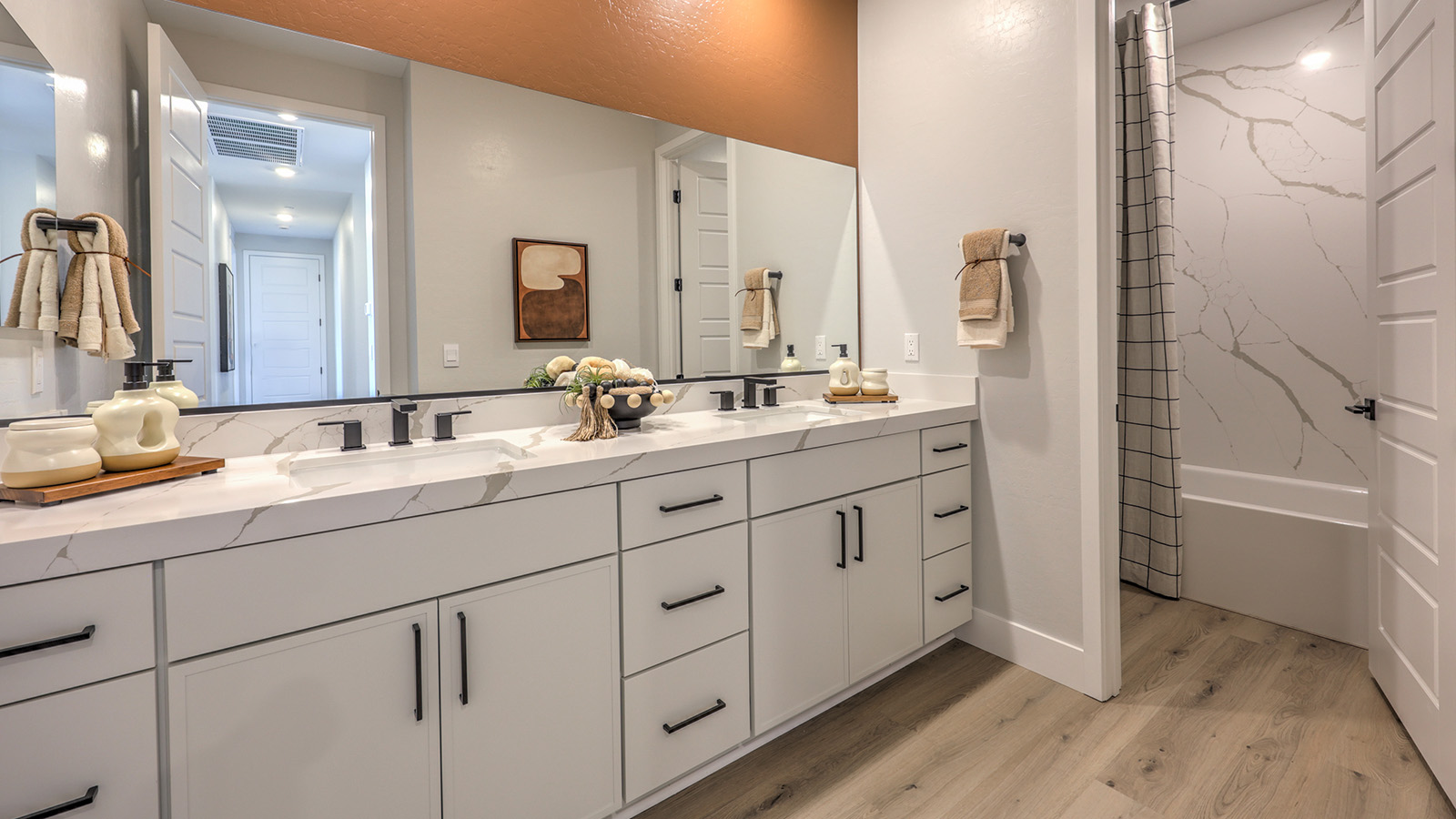 Bathroom Two in our Heartland Summit 3774 model with granite countertops at the double Bath Vanity, a walk-in shower, mirror, and white cabinets.