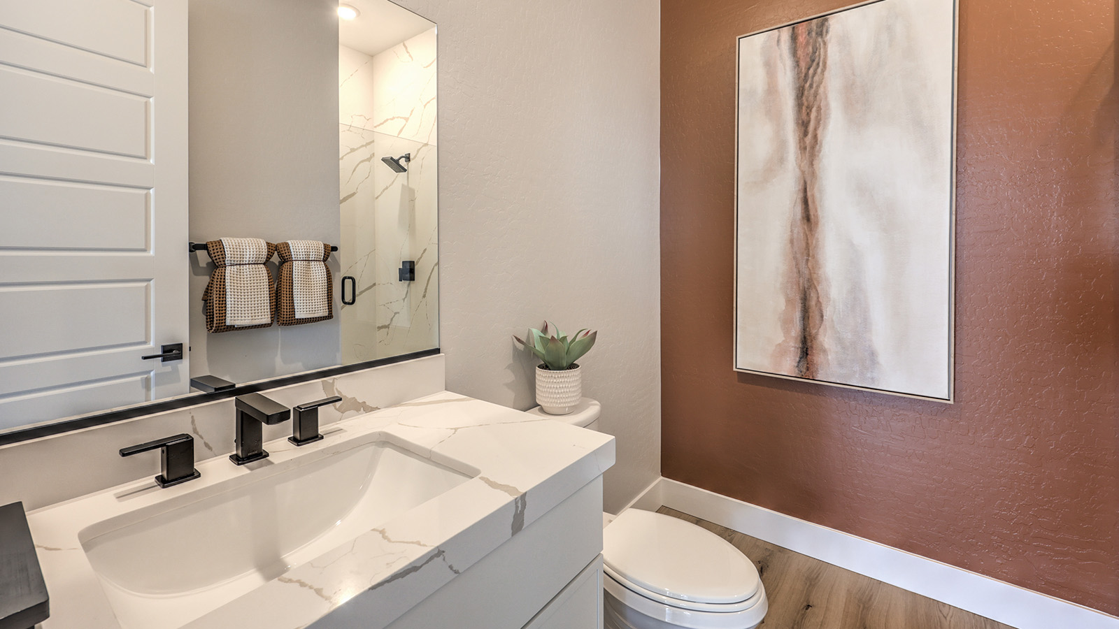 Bathroom Three in our Heartland Summit 3774 Multigen Suite with granite countertops at the Bath Vanity, a walk-in shower, mirror, and white cabinets.