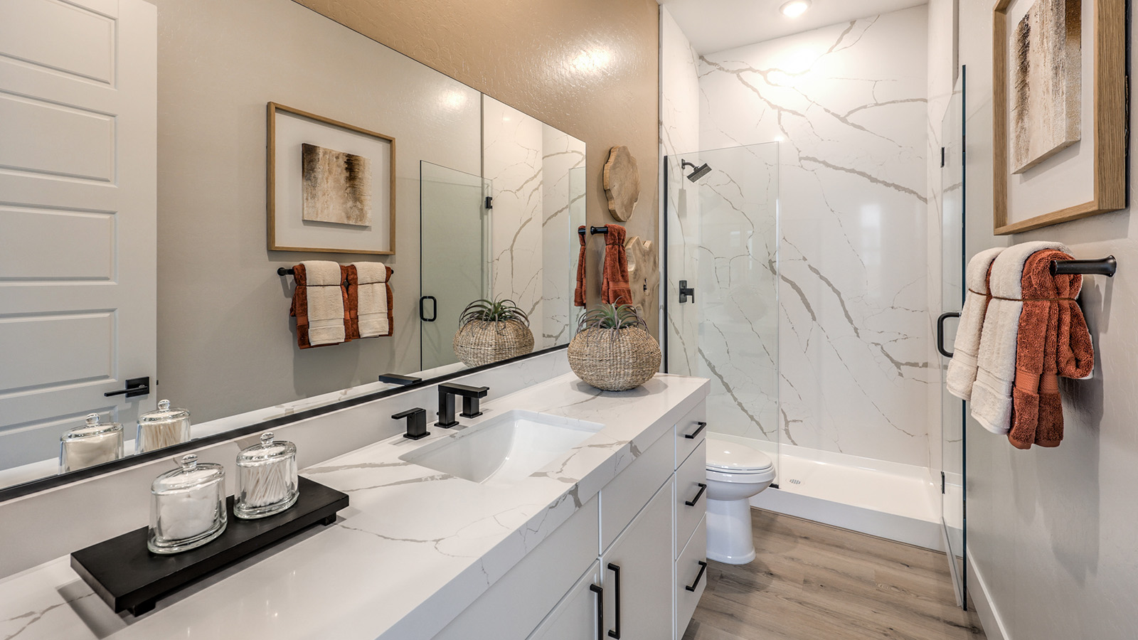 Bathroom Two in our Heartland Summit 3774 model with granite countertops at the double Bath Vanity, a walk-in shower, mirror, and white cabinets.
