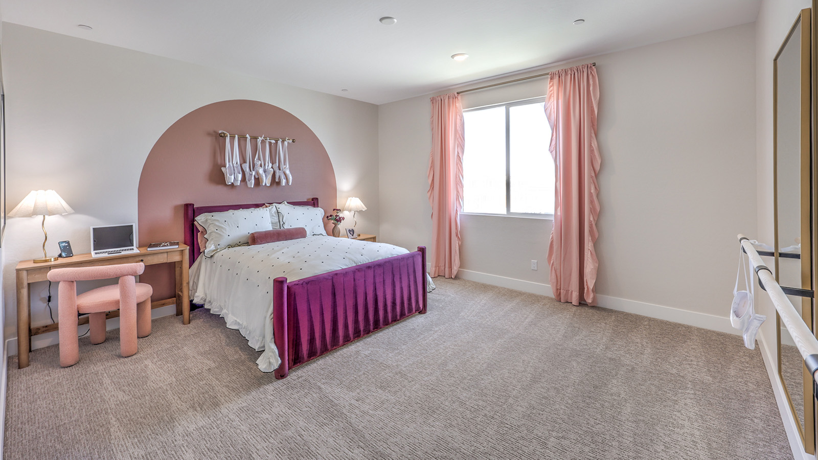 Bedroom Five in our Heartland Summit 4418 model with carpet flooring, a walk-in closet, and a window.