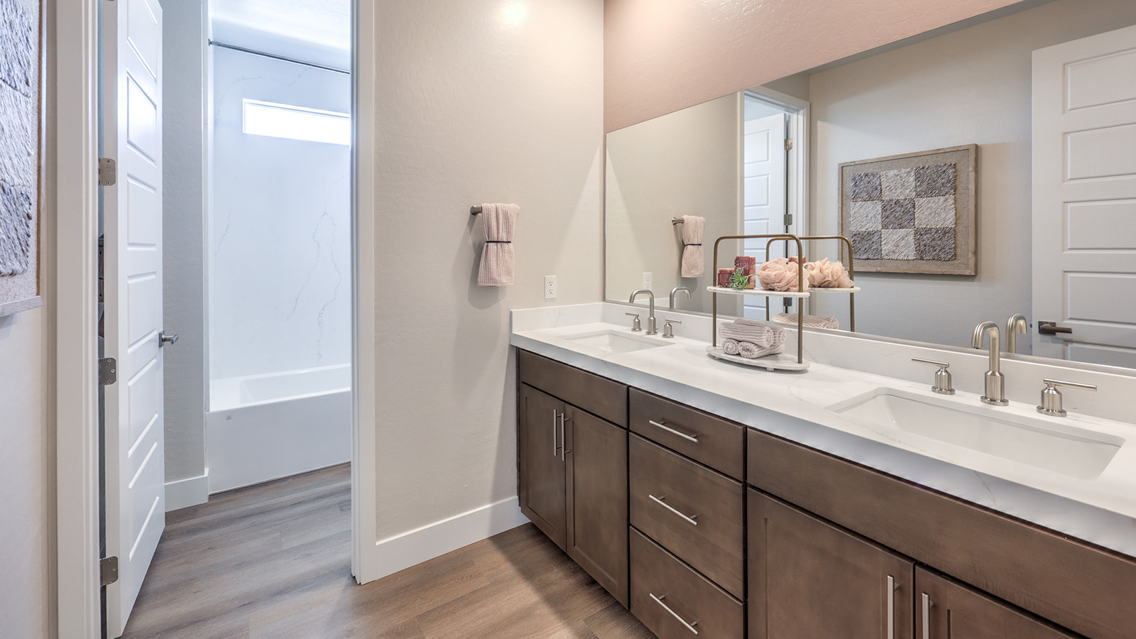 Bathroom Three in our Heartland Summit 4418 model with granite countertops at the double Bath Vanity, a walk-in shower, mirror, and brown cabinets.