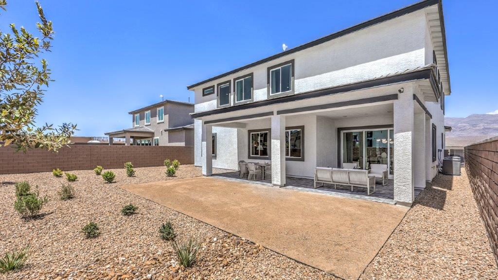 Our Heartland Summit 4418 model backyard with landscaping and a large covered patio.