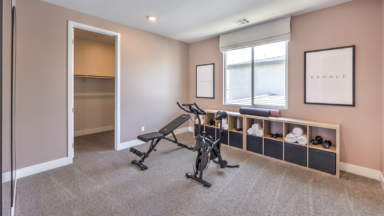 Bedroom Two in our Heartland Summit 4418 model with carpet flooring, a walk-in closet, and a window.